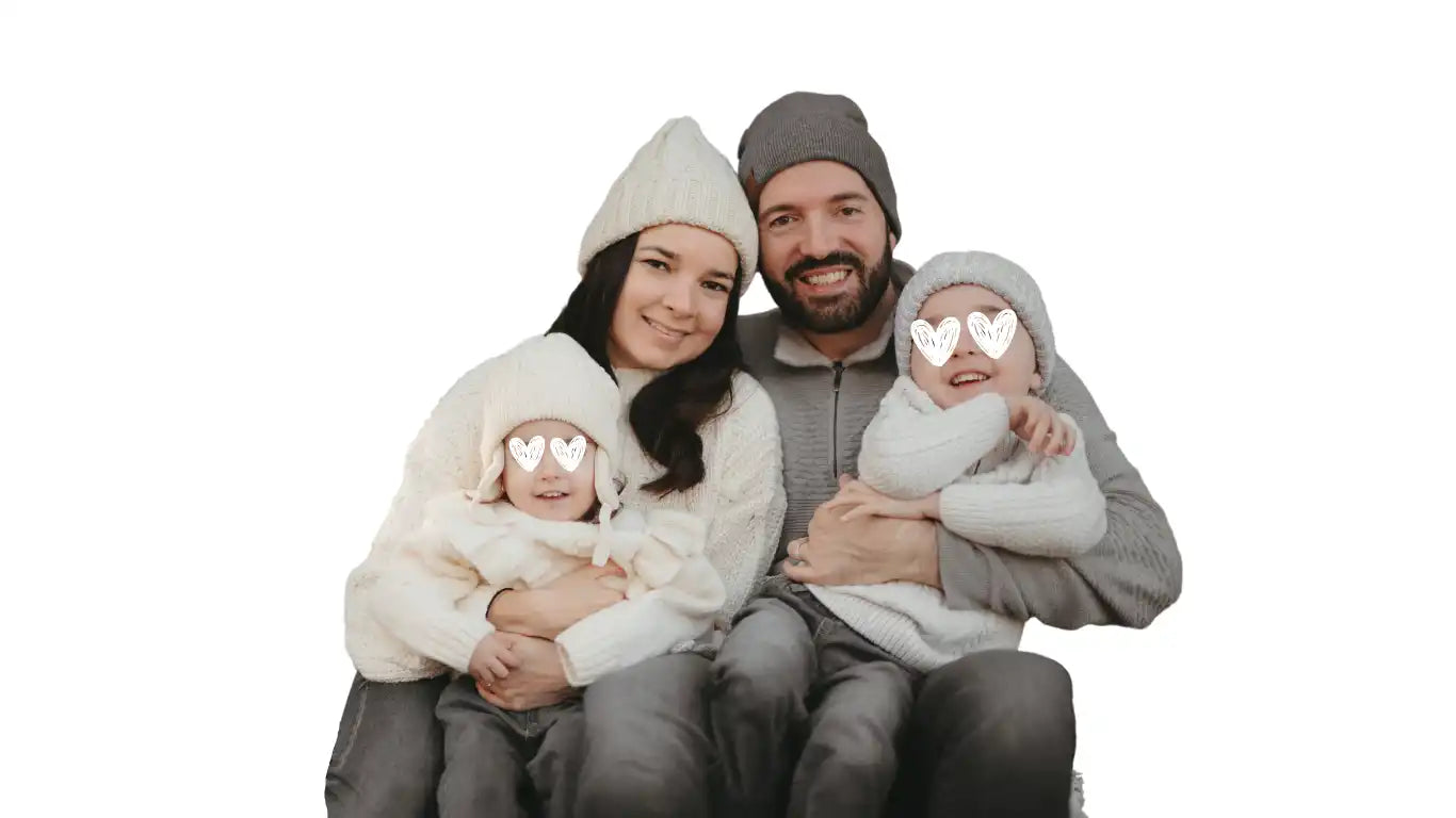 Una familia vestida con ropa de invierno y gorros sentada junta.